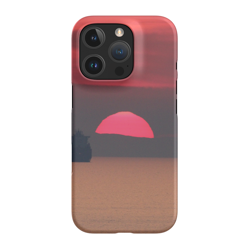 Premium cell phone case featuring Sam Gilliss' "Ship at Sunset, Corsica" artwork, showcasing a sunset over the Mediterranean coast.