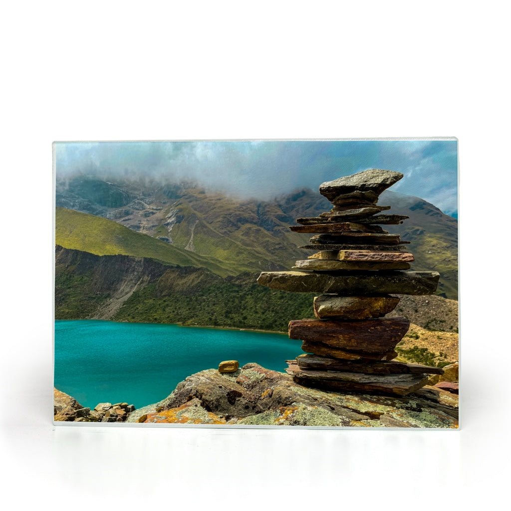 Humantay Lake in Peru on a tempered glass cutting board and elegant placemat, featuring vibrant mountain landscape artwork by Sam Gilliss.