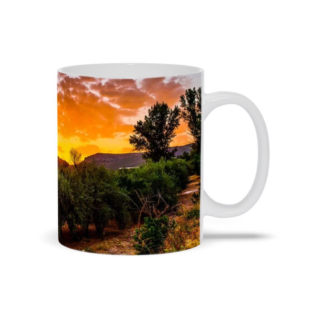 Ceramic coffee mug featuring a sunset over olive groves in Central Spain, with vibrant landscape artwork by Sam Gilliss Visual Arts.