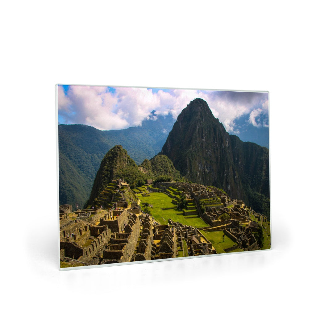 Tempered glass cutting board and placemat featuring Machu Picchu, Peru design by Sam Gilliss, showcasing Incan Empire imagery.